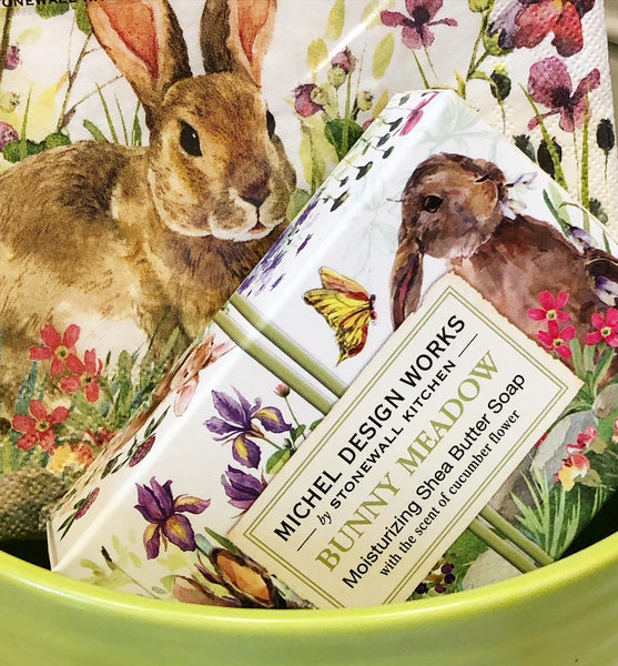 Soap bar & napkins with rabbit and floral design packaging in a green bowl.