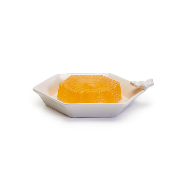 Side view of Two's Company Bee Clean Soap, unwrapped, in Porcelain Honeycomb Dish
