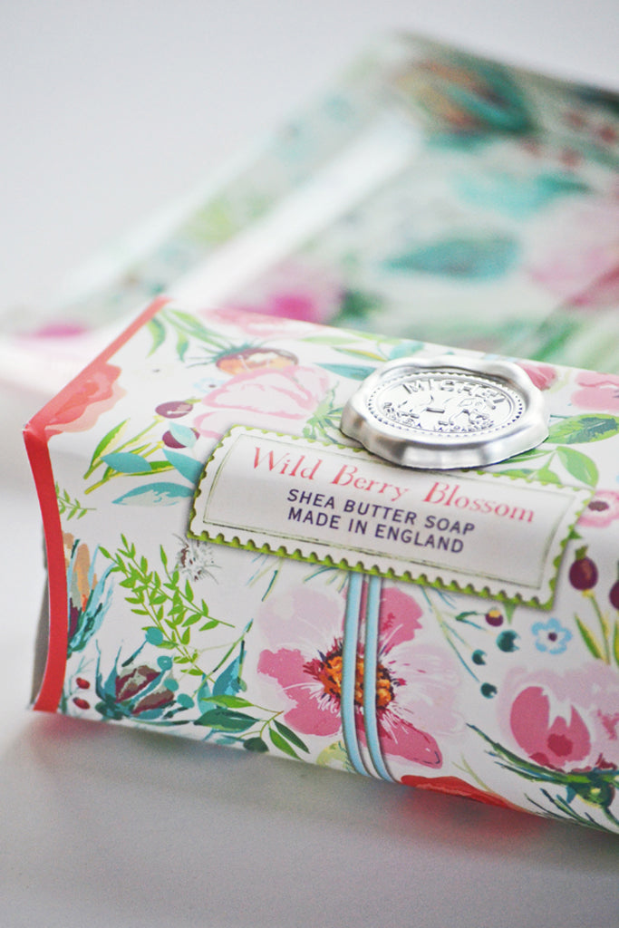 Shea butter soap bar with floral packaging on a white background