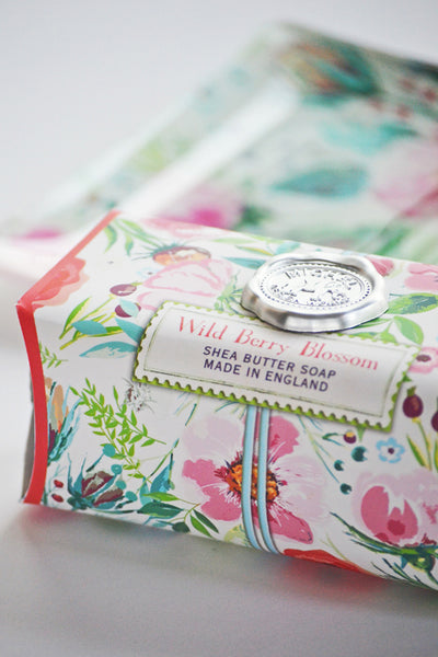 Shea butter soap bar with floral packaging on a white background