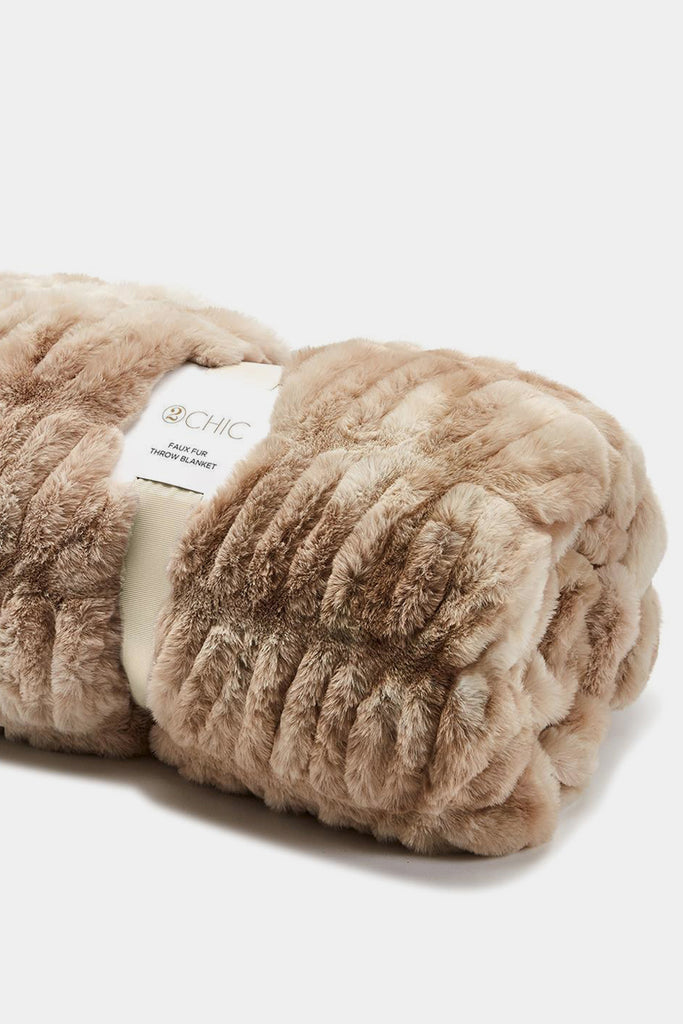 Beige plush blanket with a label on a white background