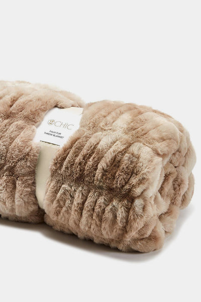 Beige plush blanket with a label on a white background