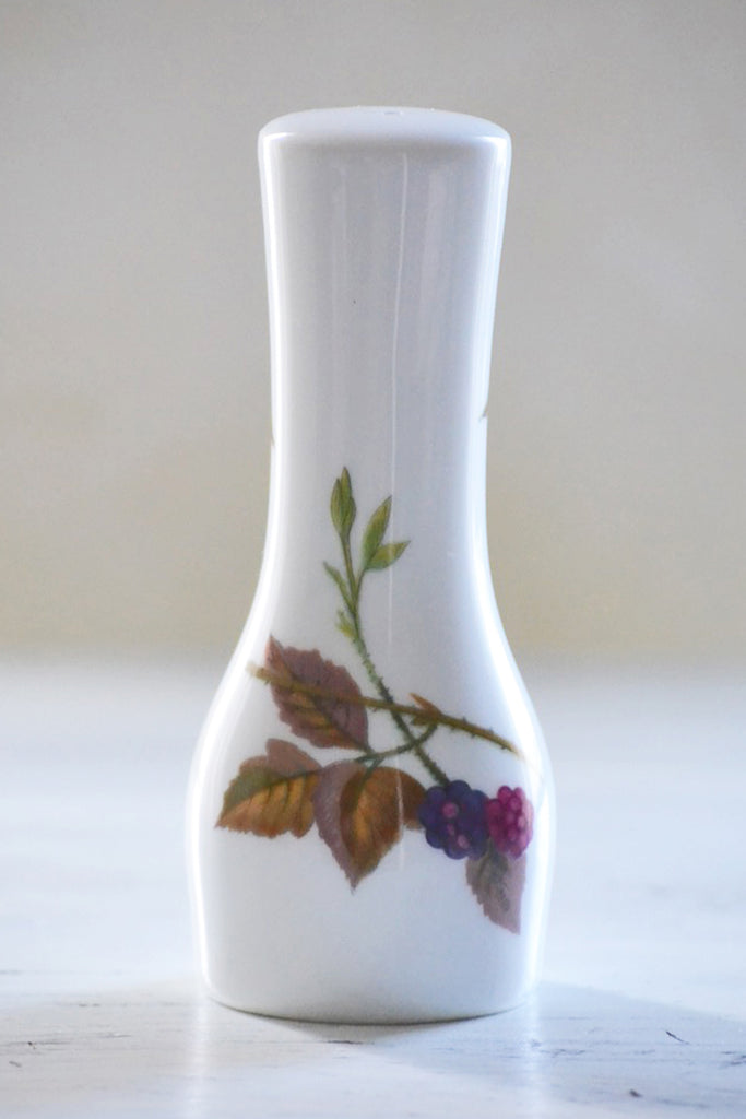 White Salt Shaker with Berries on Wood Surface