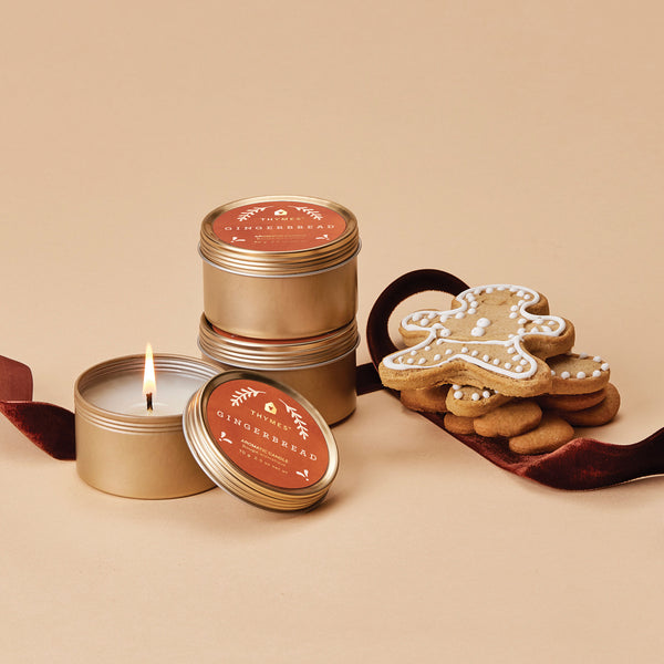 Thymes Gingerbread Travel Candles shown with Gingerbread man cookies.