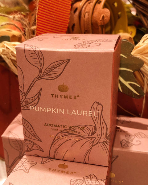 Thymes Pumpkin Laurel candle box with illustrations in a fall setting