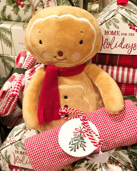 Gingerbread-themed plush toy with a red scarf on a festive background