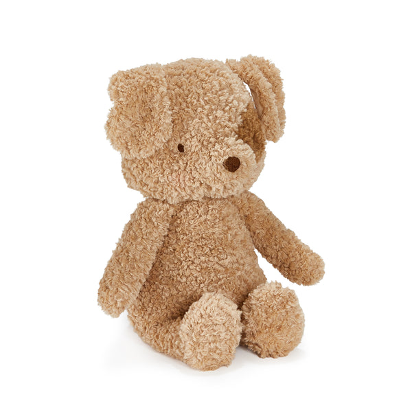 A small plush teddy bear dog in a curly, bouclé-like fabric, sitting upright against a plain white background.
