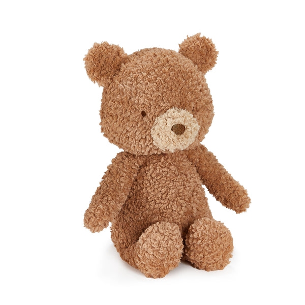A plush teddy bear toy in a warm medium brown bouclé fabric, featuring a contrasting light beige snout and nose, sitting against a solid white background.