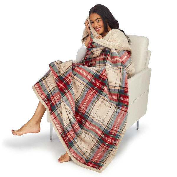 Model sitting with Two's Company Soft Tartan & Sherpa Throw Blanket