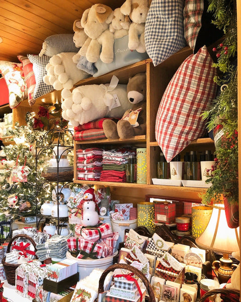 Shelf with Christmas-themed decorative items including teddy bears, plaid pillows, and ornaments.