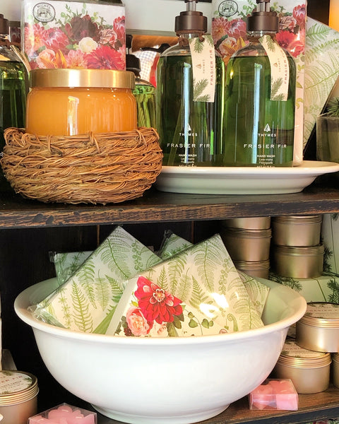 Fern Cocktail Napkins in a bowl on a shelf with Thymes Fragrances & Michel products