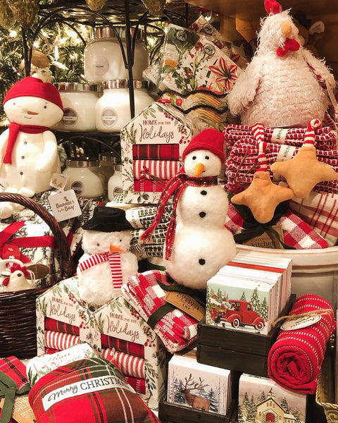 Collection of Christmas-themed decorative items including snowmen, Kitchen Towels, Candles, and Notepads