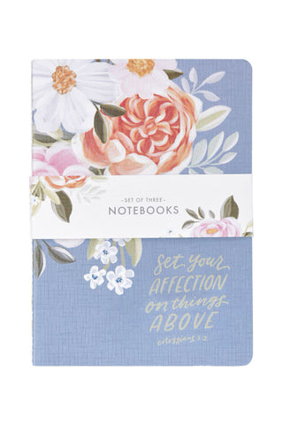 Set of three notebooks with floral design and motivational quote on a white background