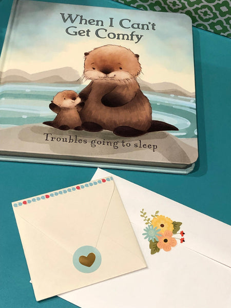 Children's book titled 'When I Can't Get Comfy' with a otter illustration on a teal counter.