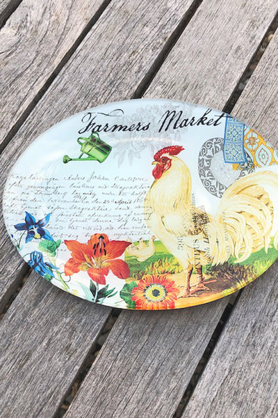 Decorative plate with a rooster design on a wooden surface