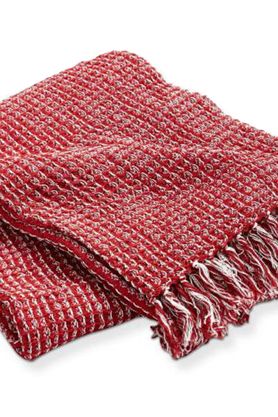 Red woven blanket with fringes on a white background