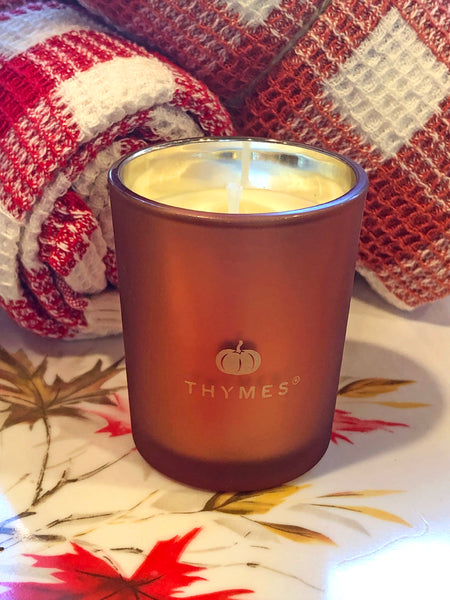 Thymes candle in a decorative container on vintage tray with Rolled Gingham Waffle Kitchen Towels in background