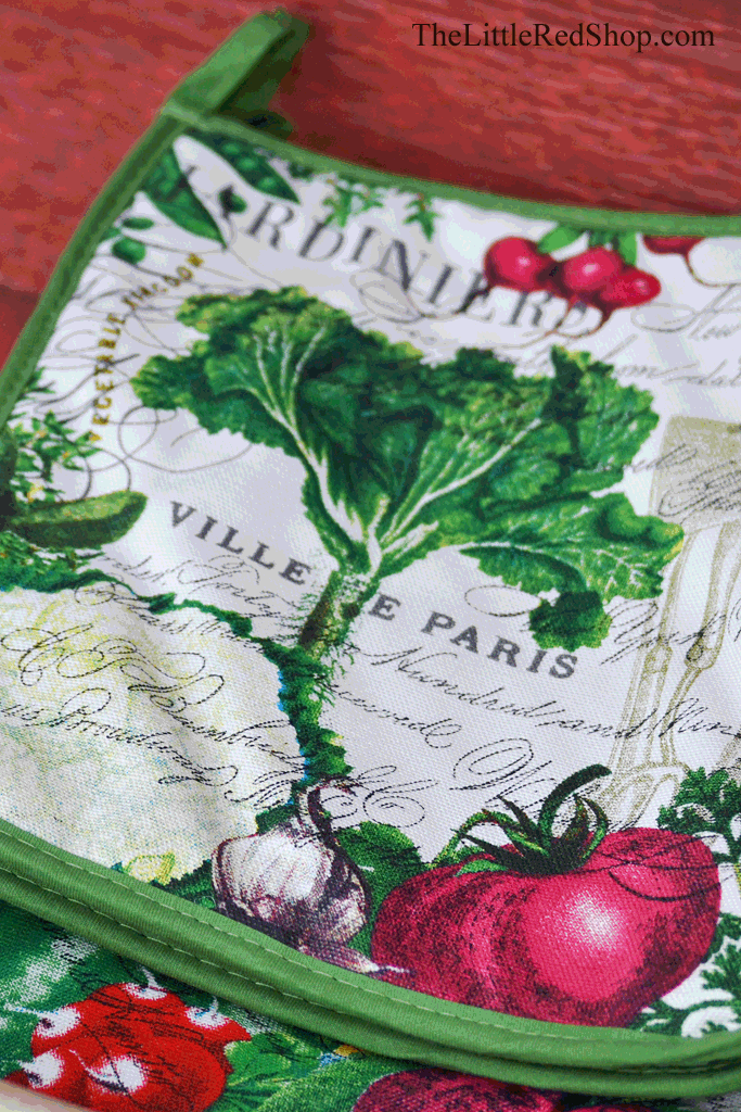 Detail of From My Garden Kitchen Potholder featuring tomatoes, cauliflower, radishes, peas, and other vegetables