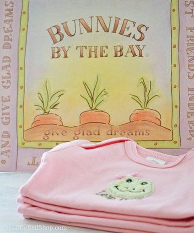 A folded stack of Bunnies by the Bay's Pink Lily Mae Leap Frog Bunsie Baby Onesie